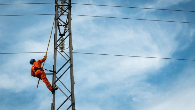 A lineworker tests for faults on medium-voltage power lines in Abuja, Nigeria